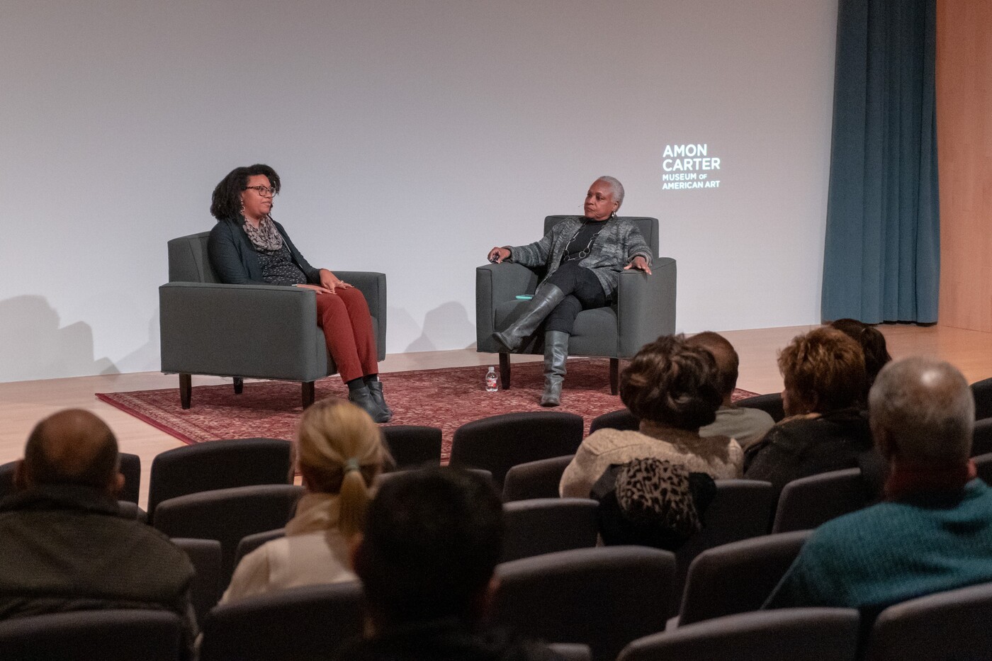 Two women sitting in chairs on stage in the Carter&#039;s auditorium.