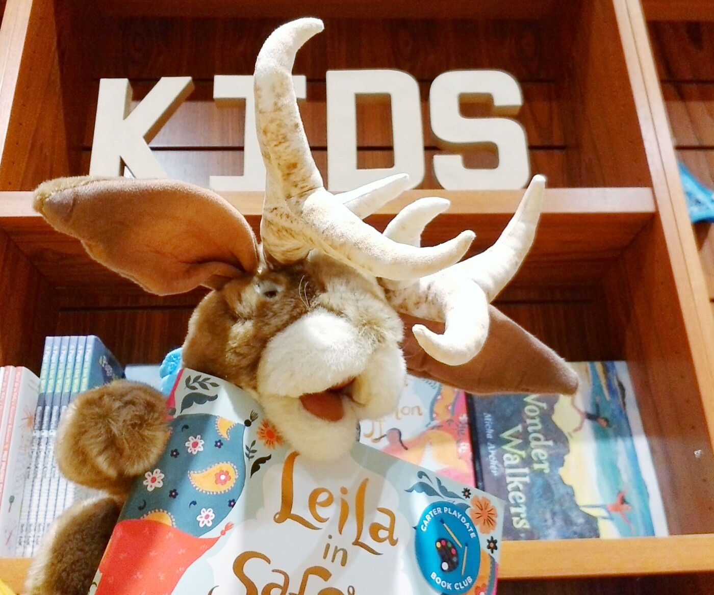Prickles the jackalope puppet holds a book in the Museum Shop.