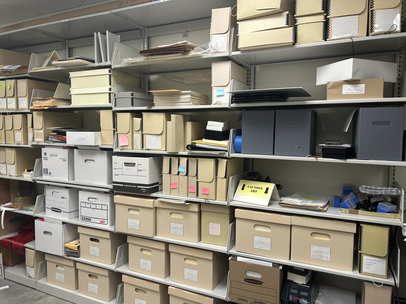 A wall of shelves containing boxes, files, and papers.