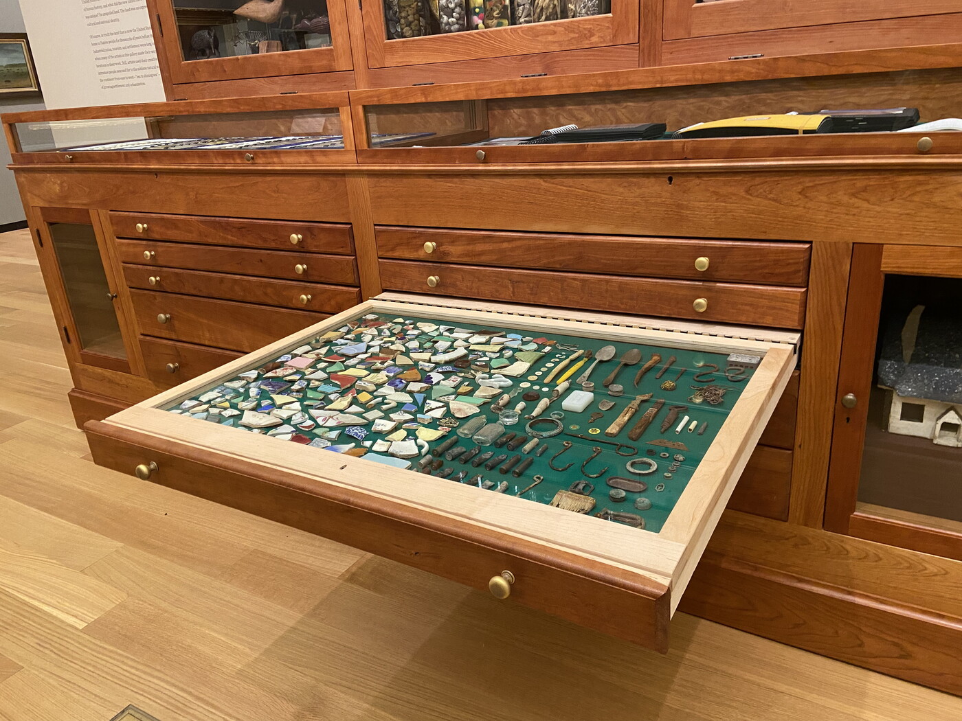 A drawer, pulled out from a larger wood cabinet, showing the objects inside.