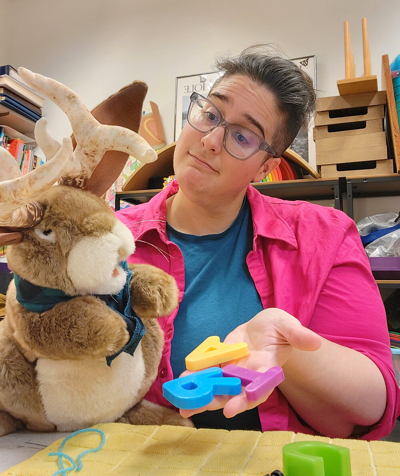 Prickles the Jackalope and a Carter educator pick out letters for their project.