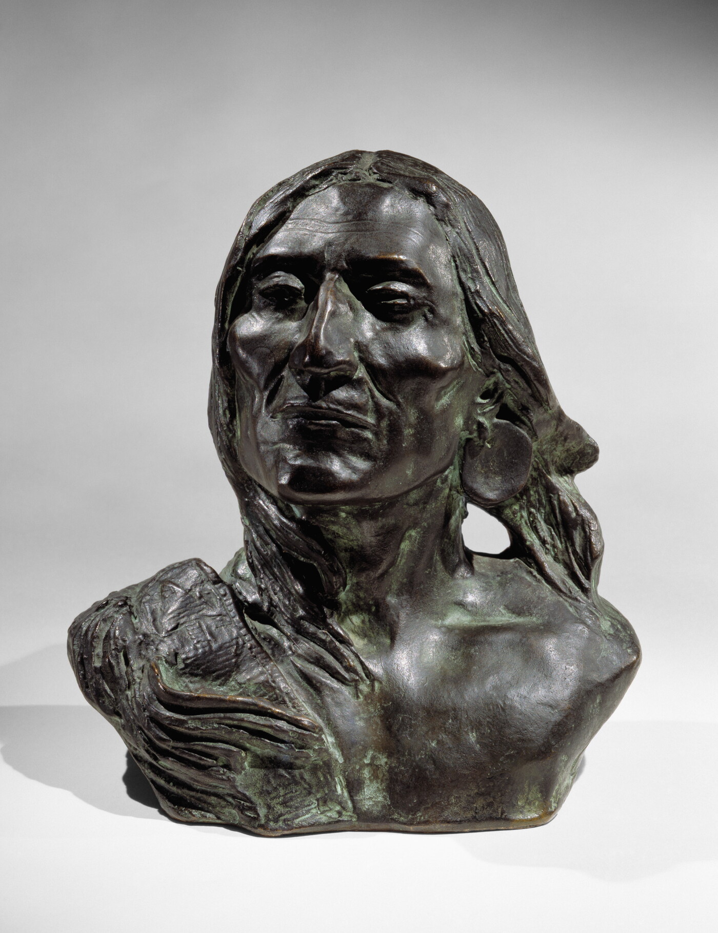 A bronze bust of an Indigenous person.