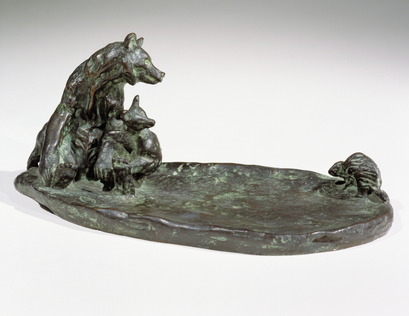 A bronze sculpture of a mother bear and her cub keeping a safe distance from a porcupine.