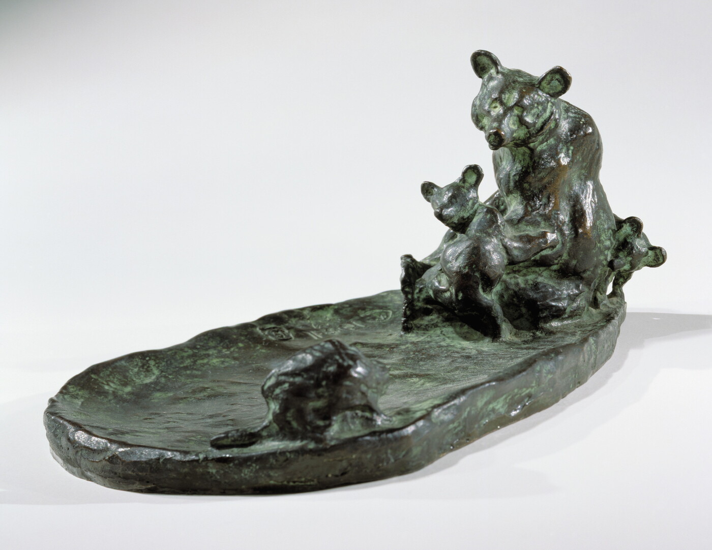 A bronze sculpture of a mother bear and her cub keeping a safe distance from a porcupine.