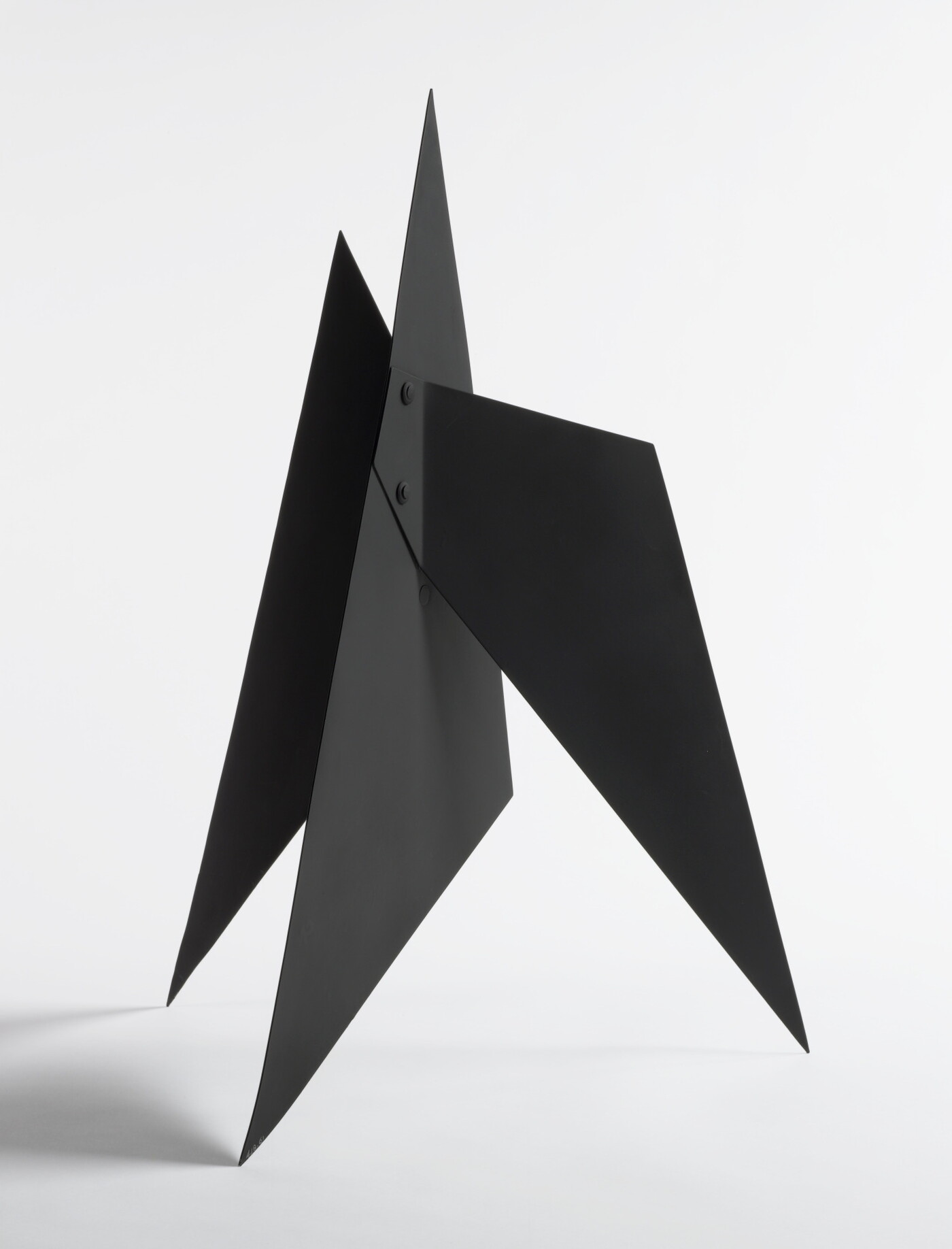 A black abstract tabletop sculpture with sharp points.