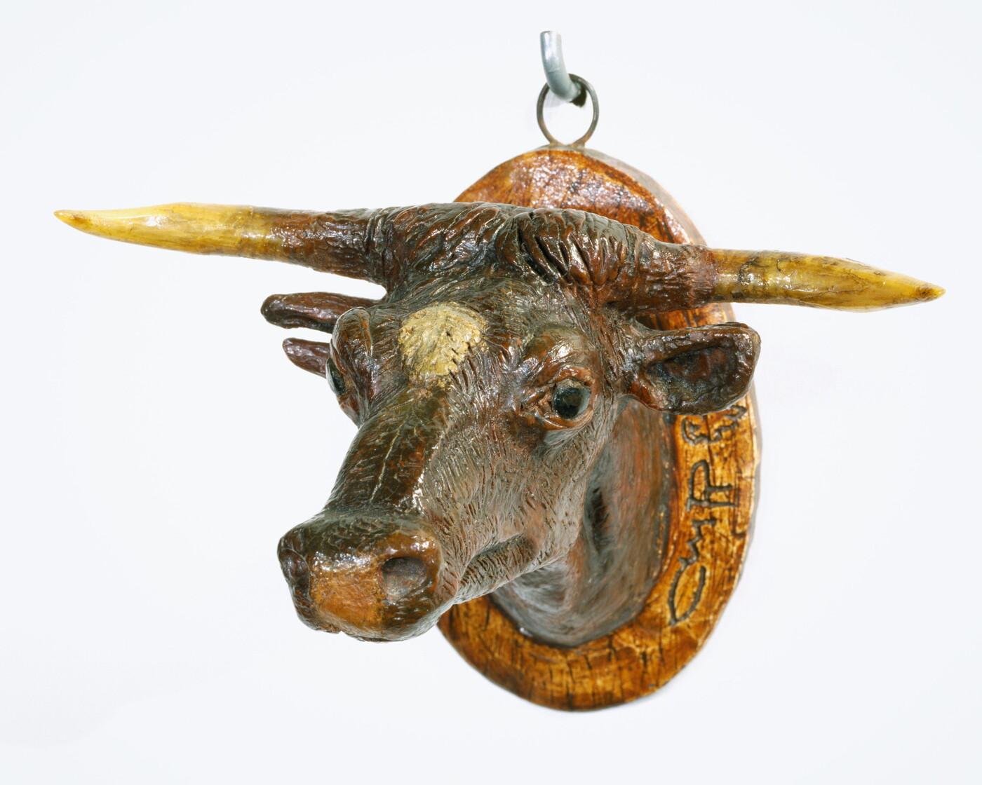 A painted sculpture of a mounted longhorn cow head.
