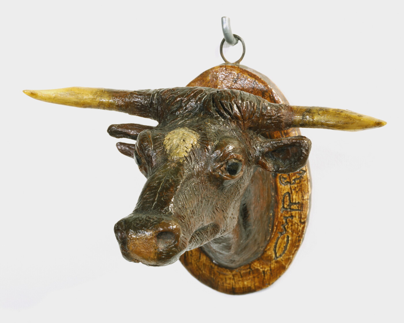 A painted sculpture of a mounted longhorn cow head.