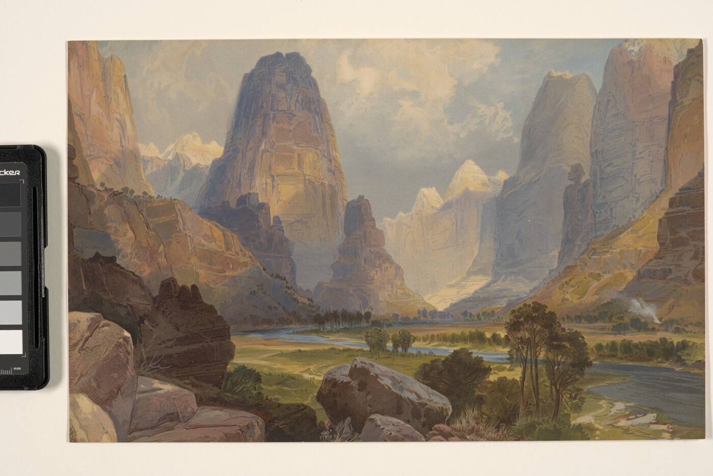 A color print of a landscape with rocky cliffs, mountains, and a river.