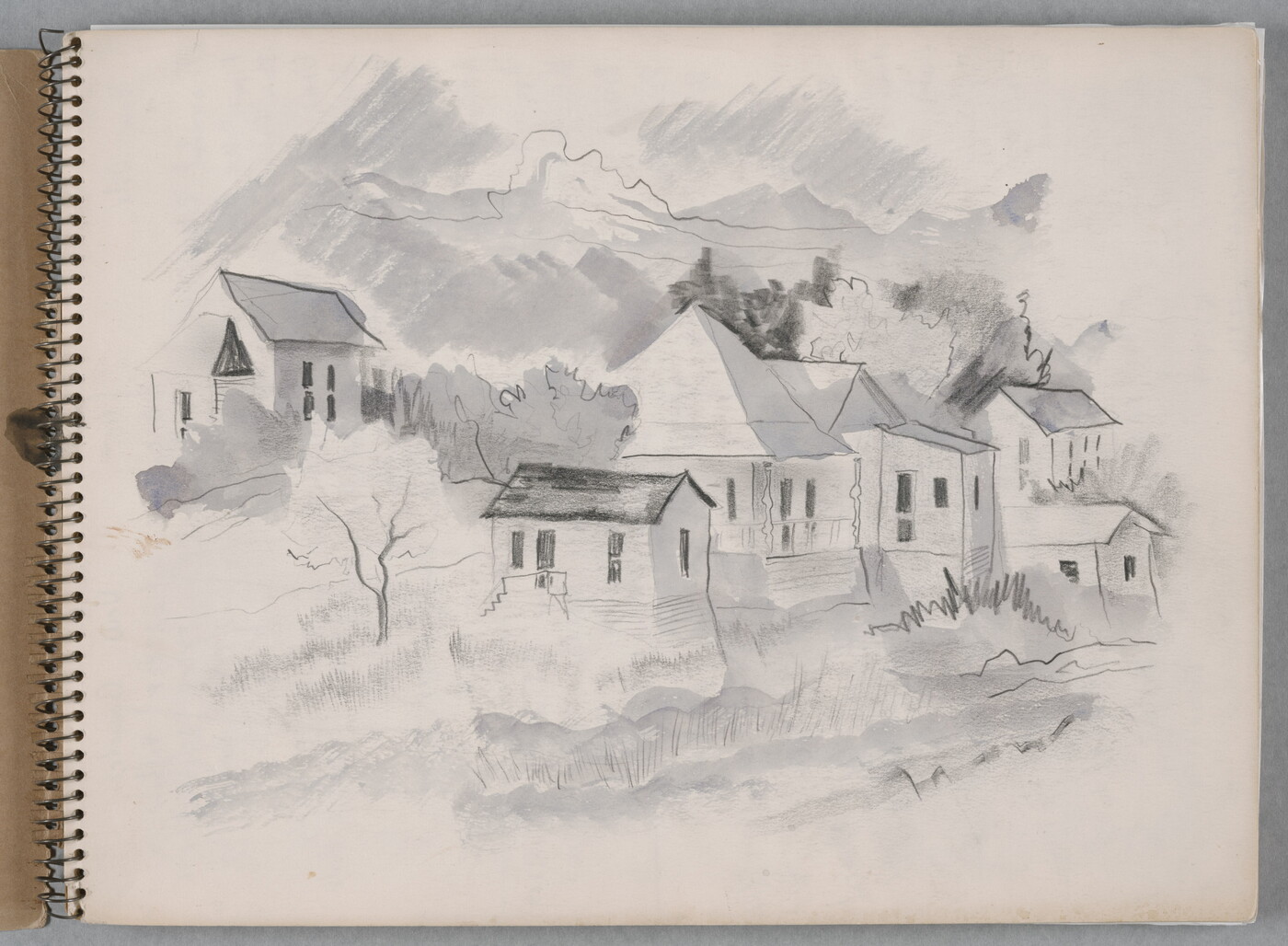 A black-and-white watercolor in a spiral sketchbook of six houses built into the side of a hill.