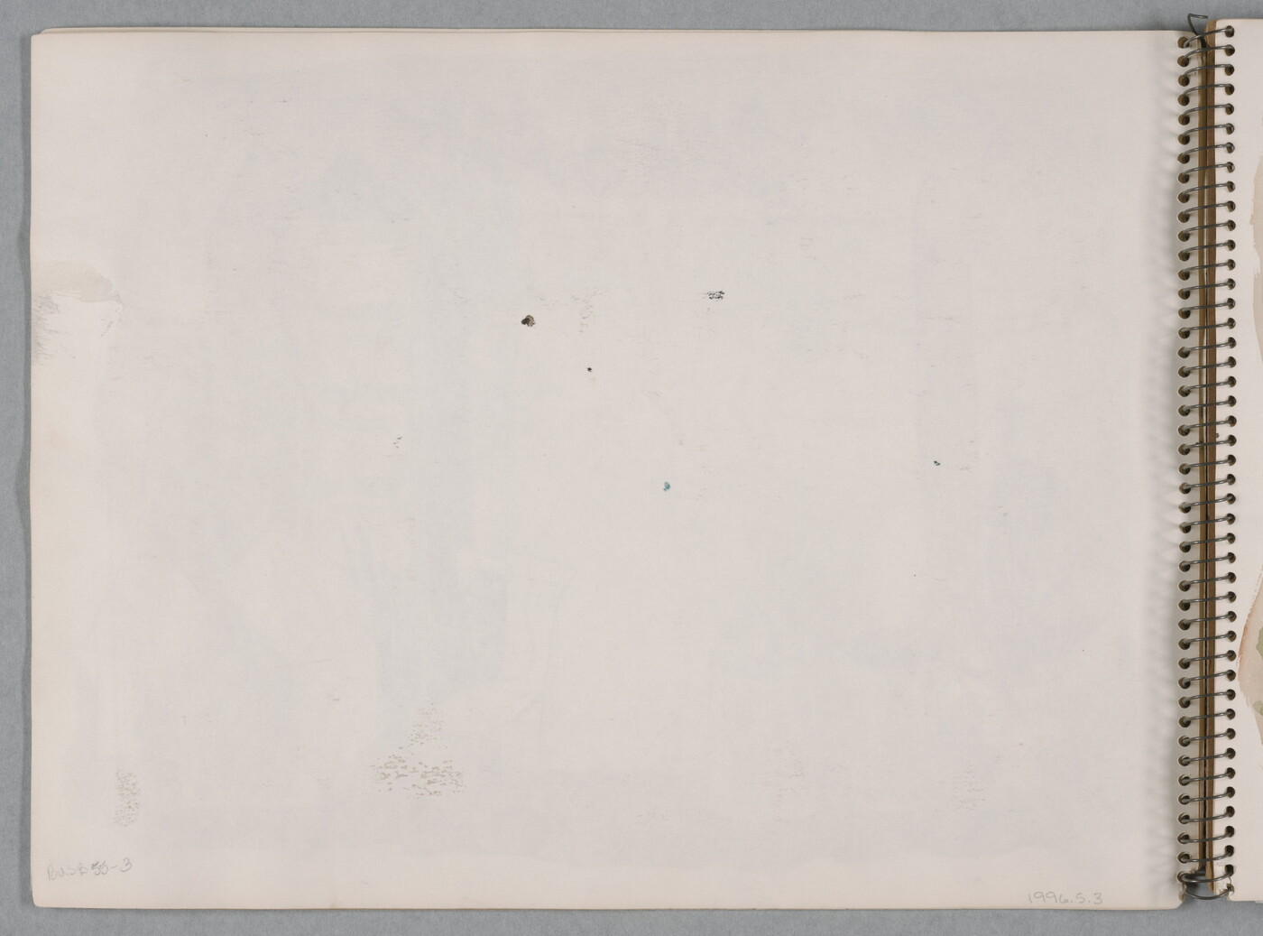 A watercolor drawing of a neighborhood street, including buildings, a chair, garbage cans, and a potted plant, on a page of a bound sketchbook.