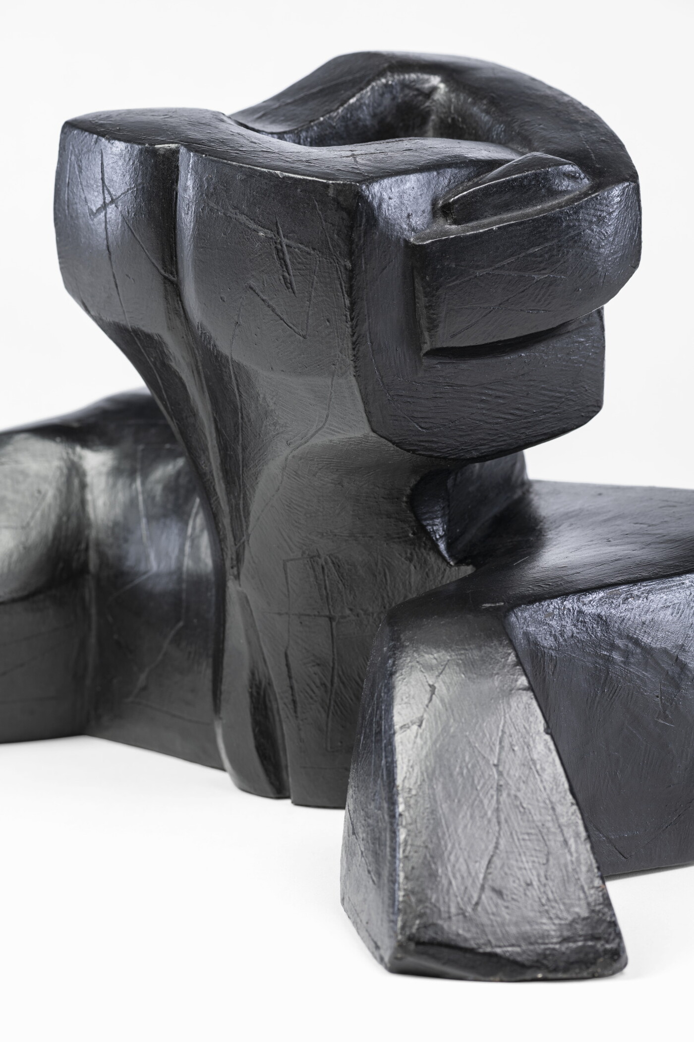 An abstract, black sculpture resembling a figure&#039;s head and shoulders.