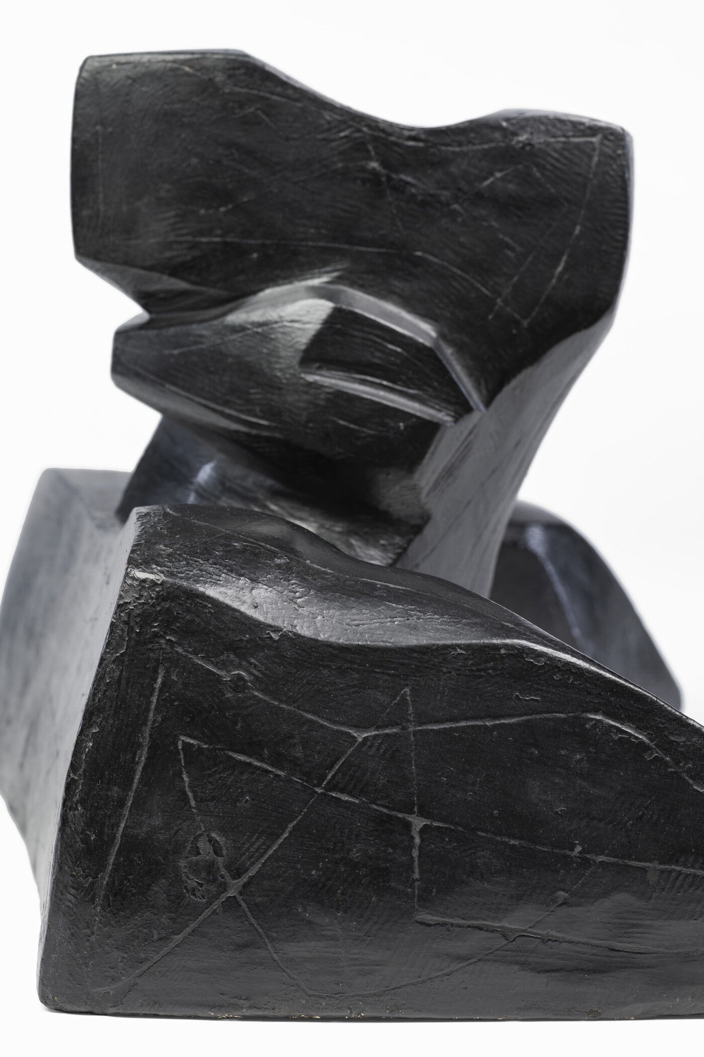 An abstract, black sculpture resembling a figure&#039;s head and shoulders.