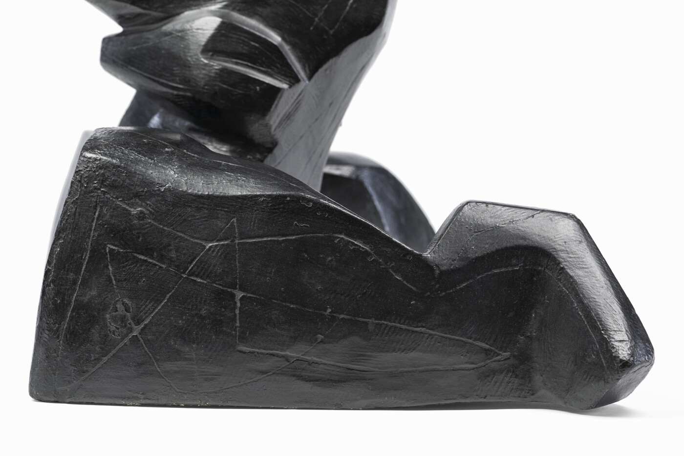 An abstract, black sculpture resembling a figure&#039;s head and shoulders.