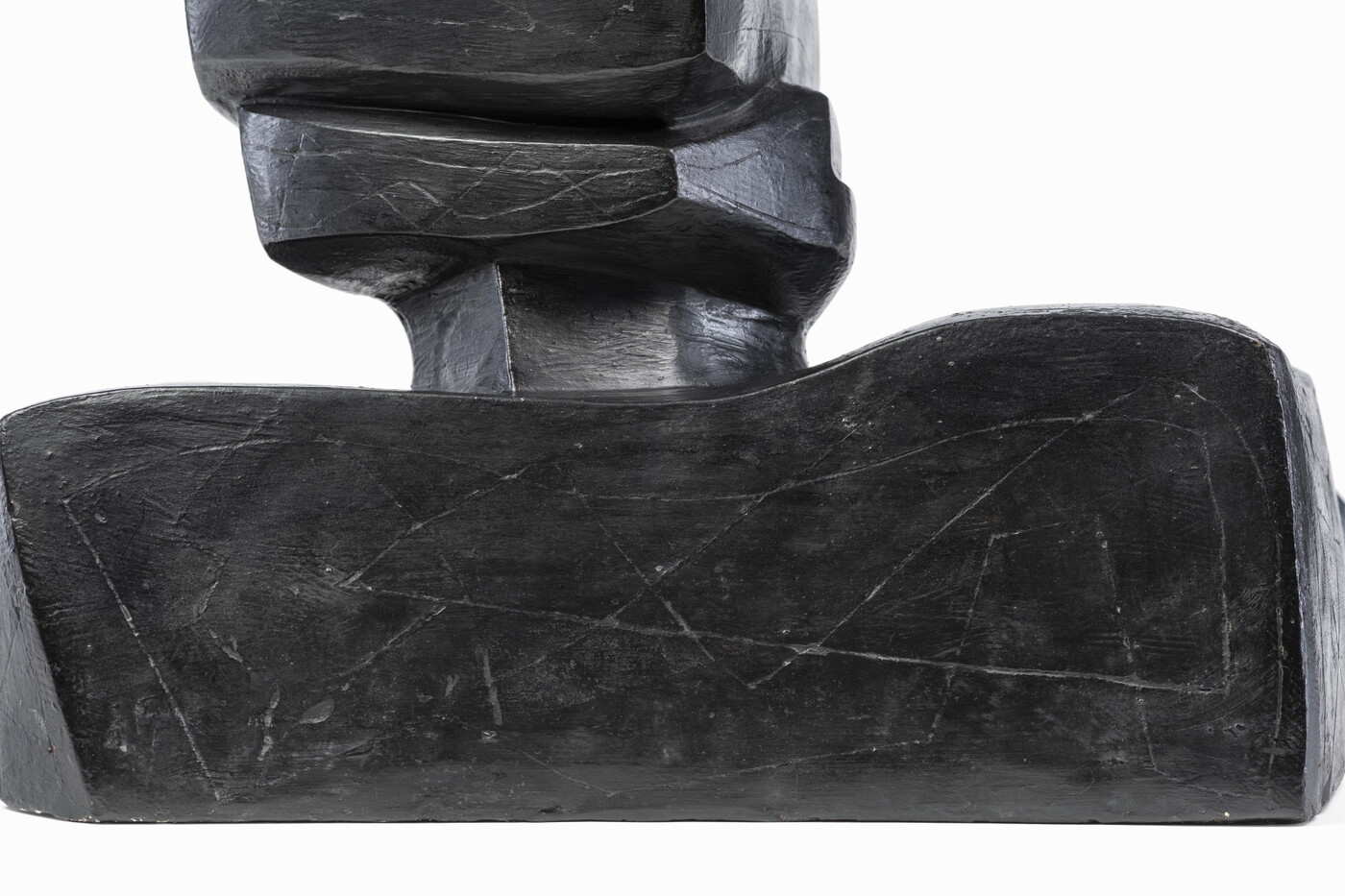 An abstract, black sculpture resembling a figure&#039;s head and shoulders.