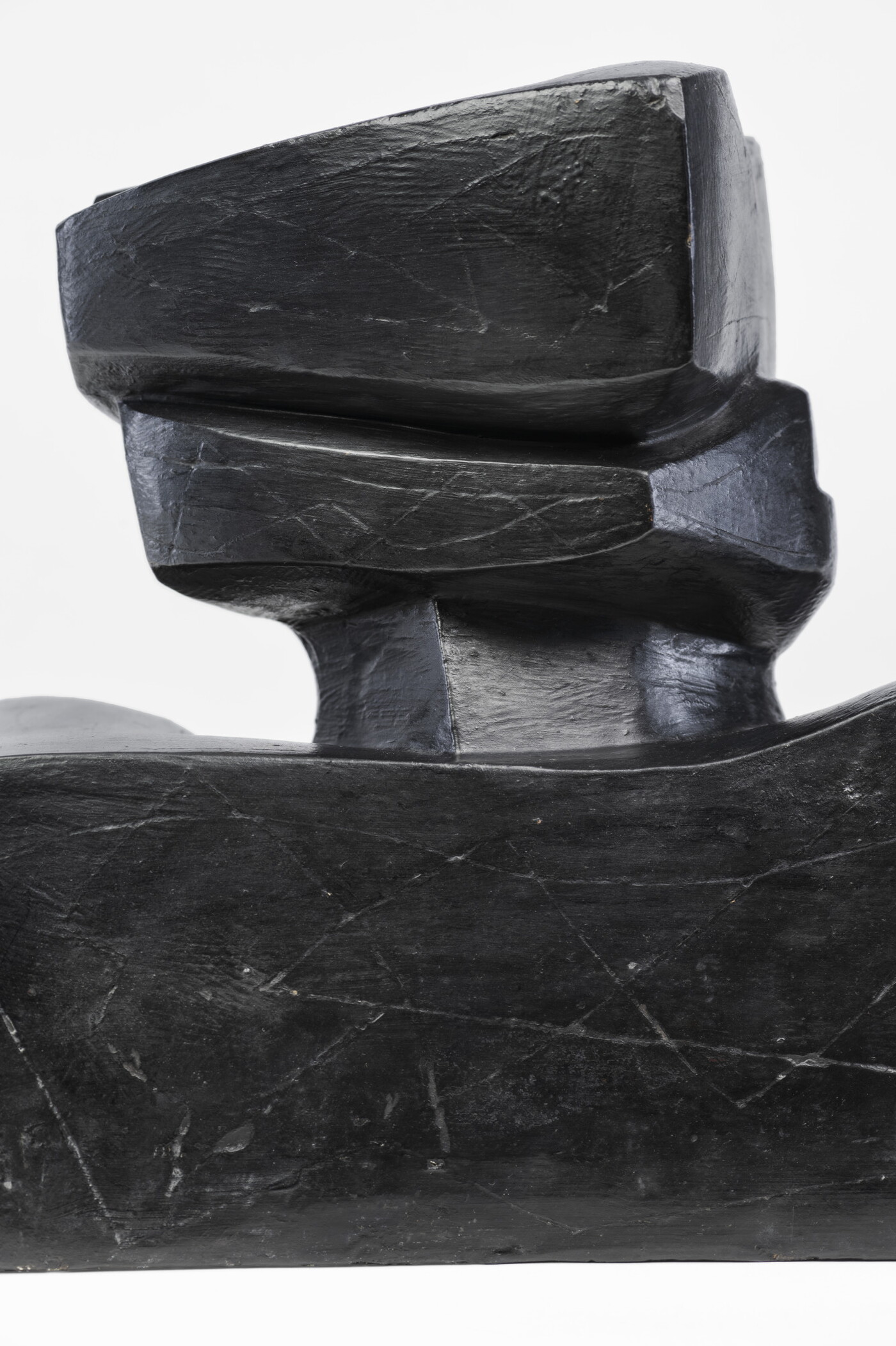 An abstract, black sculpture resembling a figure&#039;s head and shoulders.