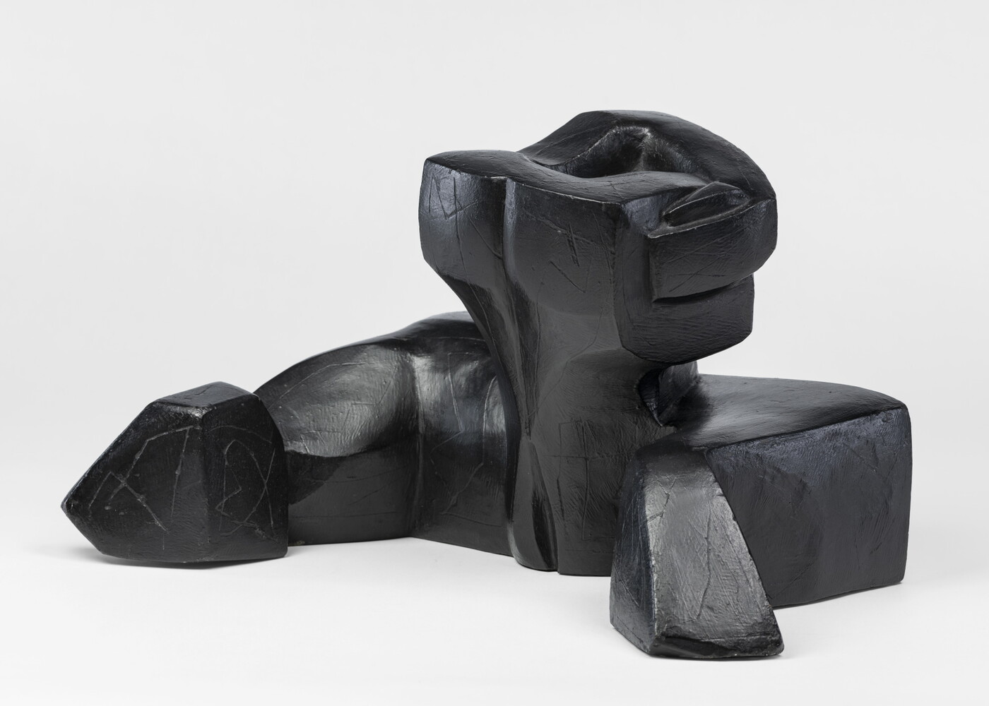 An abstract, black sculpture resembling a figure&#039;s head and shoulders.