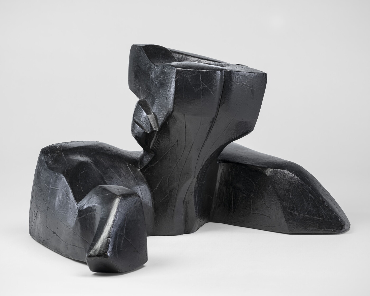 An abstract, black sculpture resembling a figure&#039;s head and shoulders.