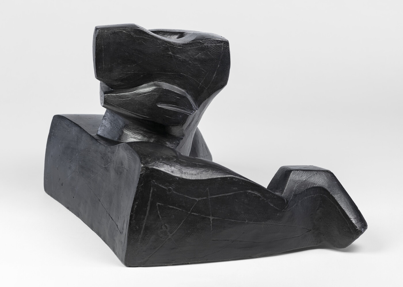 An abstract, black sculpture resembling a figure&#039;s head and shoulders.