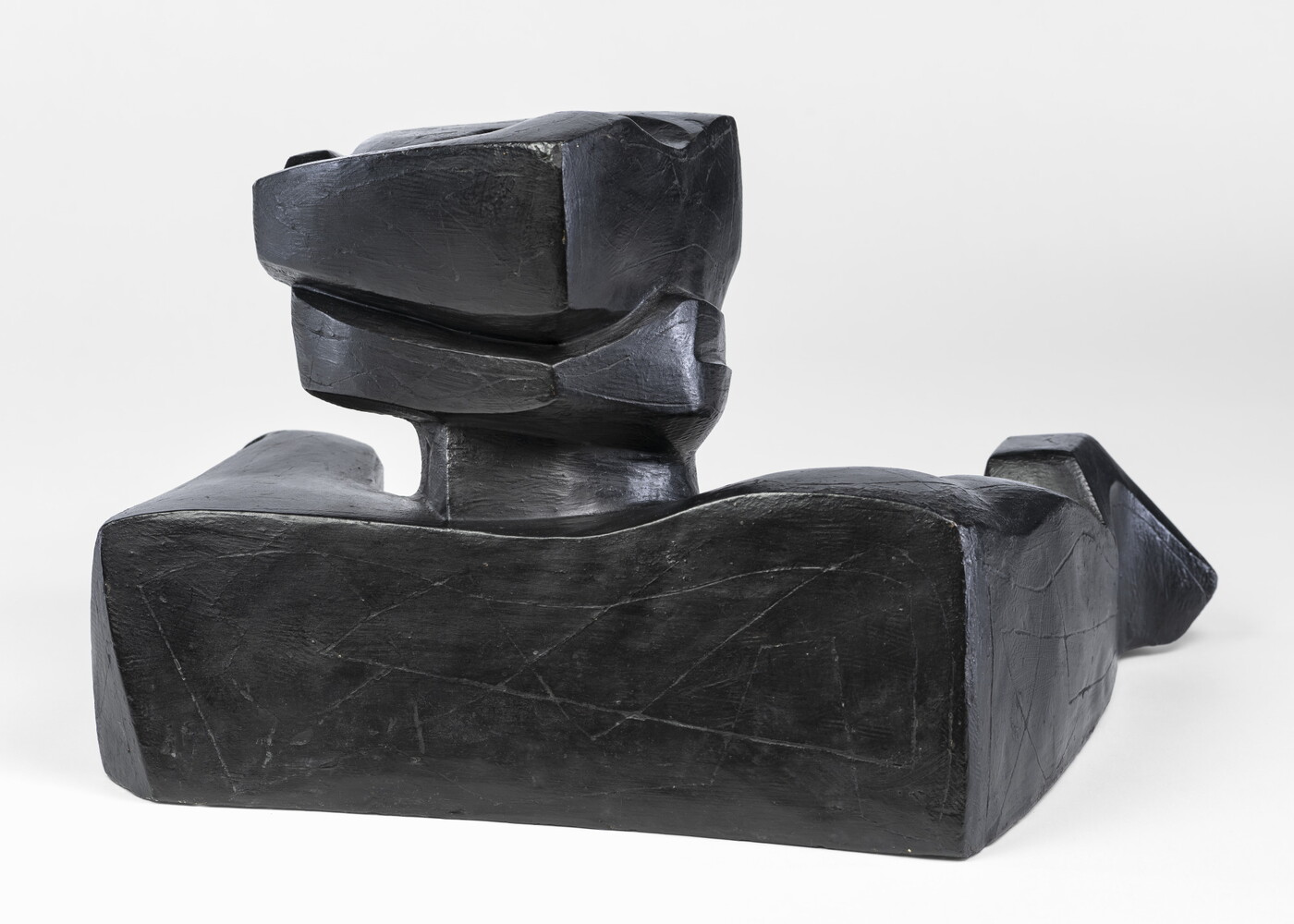 An abstract, black sculpture resembling a figure&#039;s head and shoulders.