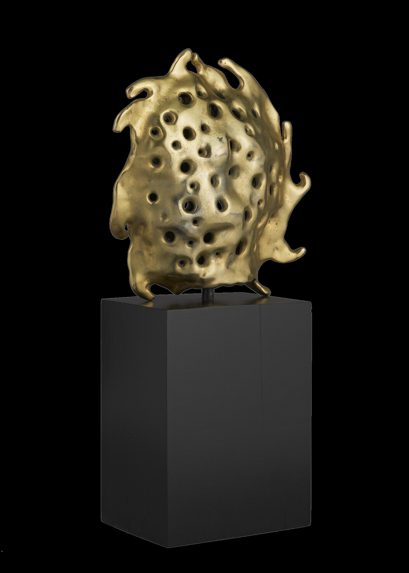 A bronze sculpture of a gold sun sitting atop a tall, dark rectangular base.