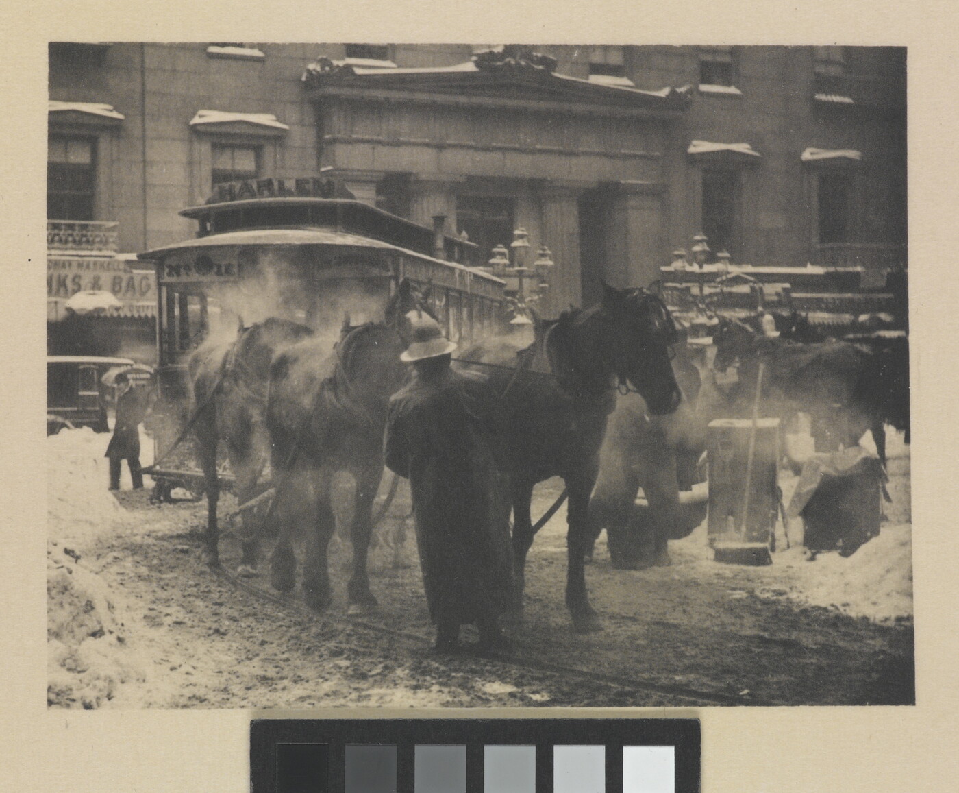 A black-and-white photograph of horses pulling a trolley on a busy street covered with slush and snow.