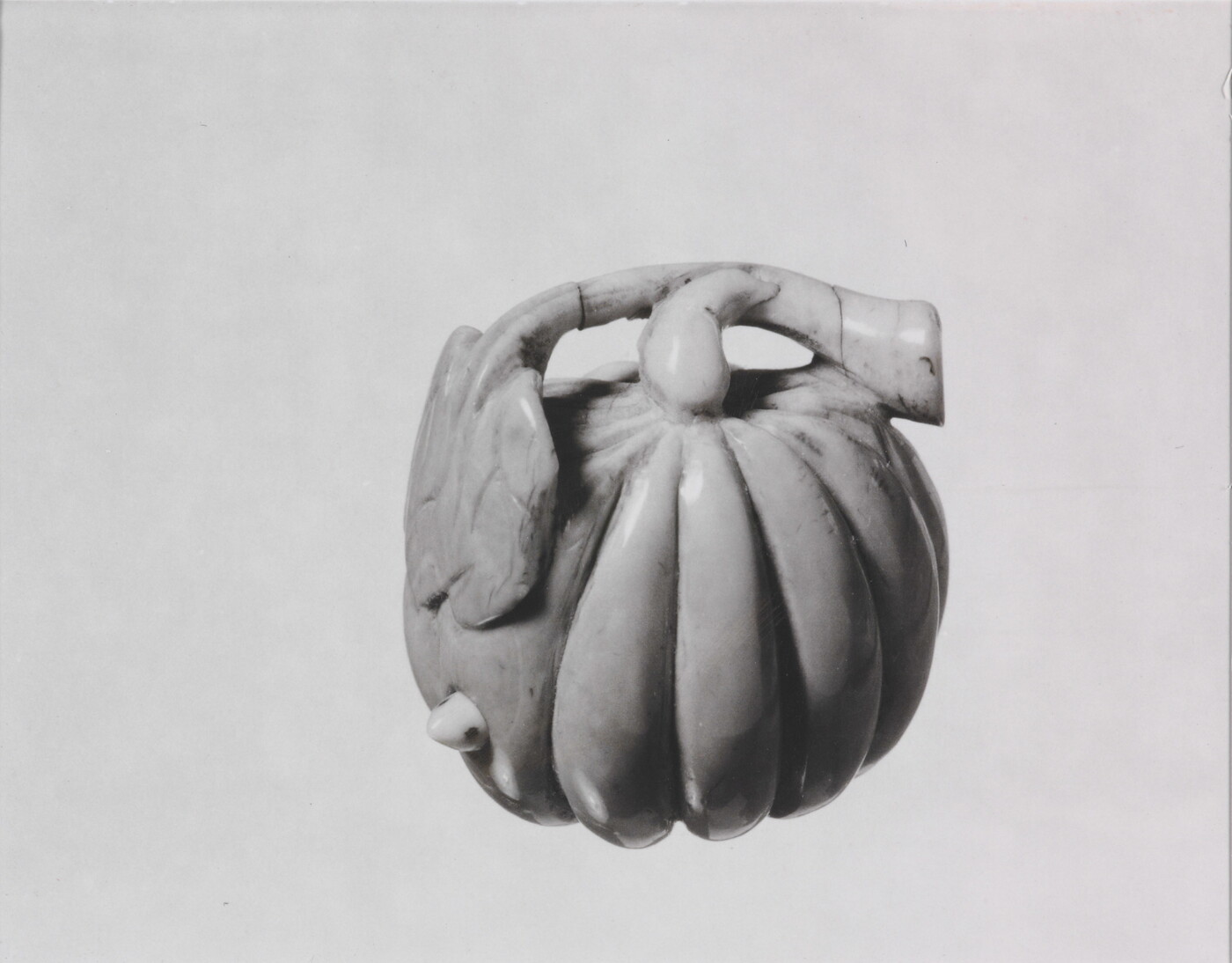 A black-and-white photograph of a ceramic pumpkin.