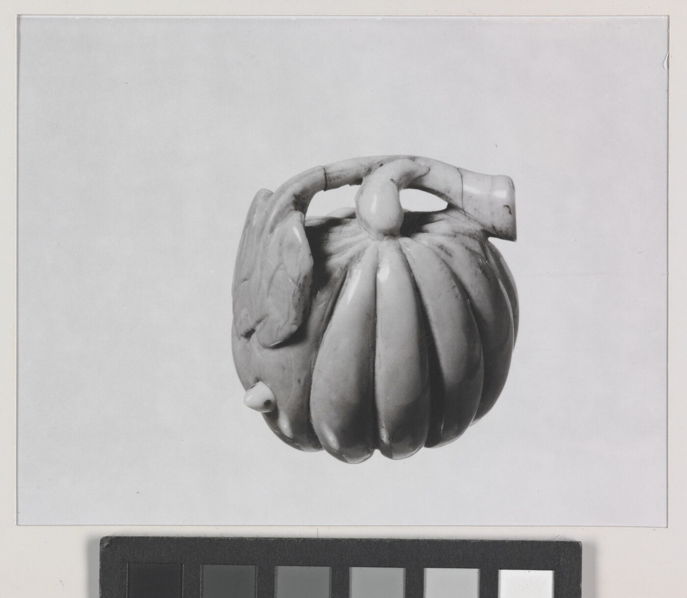 A black-and-white photograph of a ceramic pumpkin.