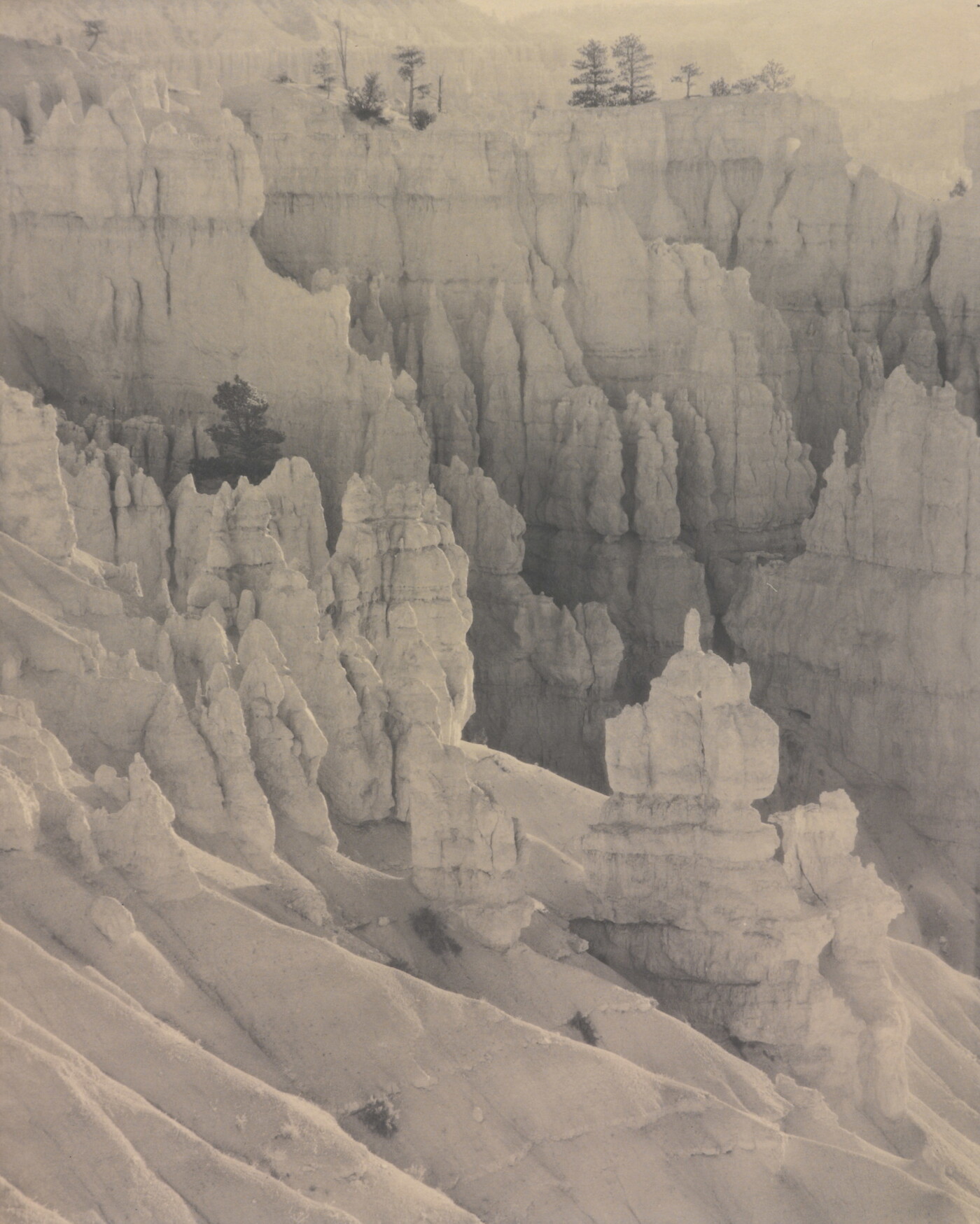 A sepia-toned photograph of rock spires as viewed from high up.