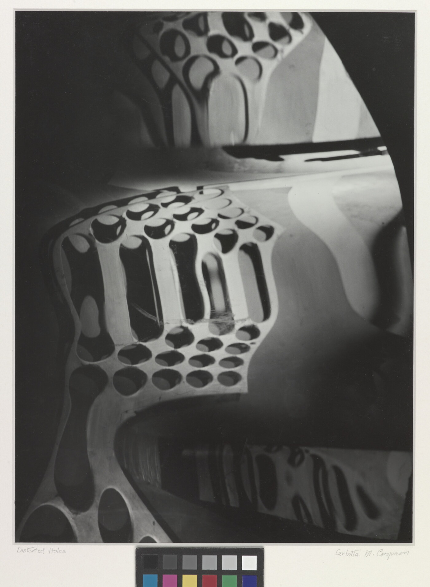A black-and-white photograph of circular shapes distorted by a wavy mirror.