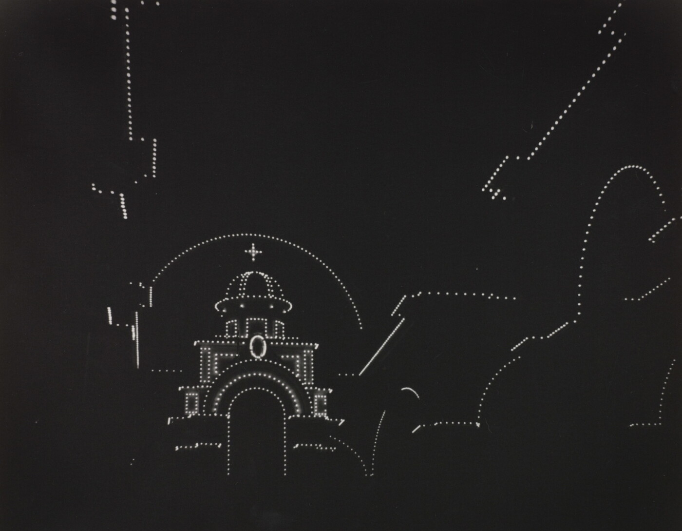 A black-and-white photograph with a pure black background and dotted white lights outlining the shape of a domed cathedral.