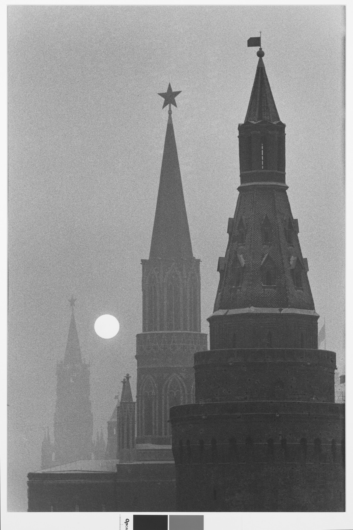 A black-and-white photograph of three spires fading into the distance with a bright, full moon rising.