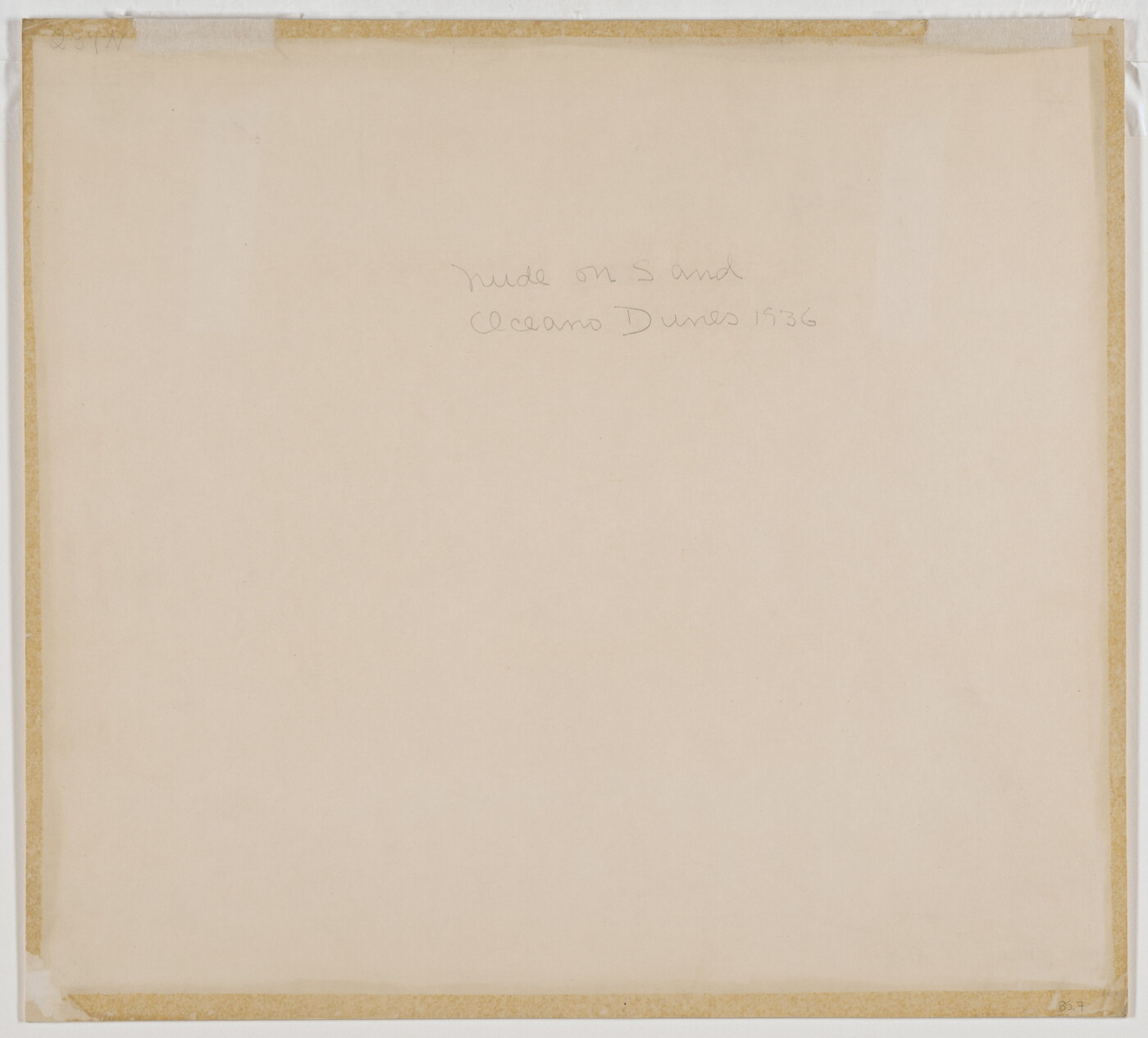 A black-and-white photograph of a nude, fair-skinned woman lying facedown in the sand with her head resting on her crossed arms.