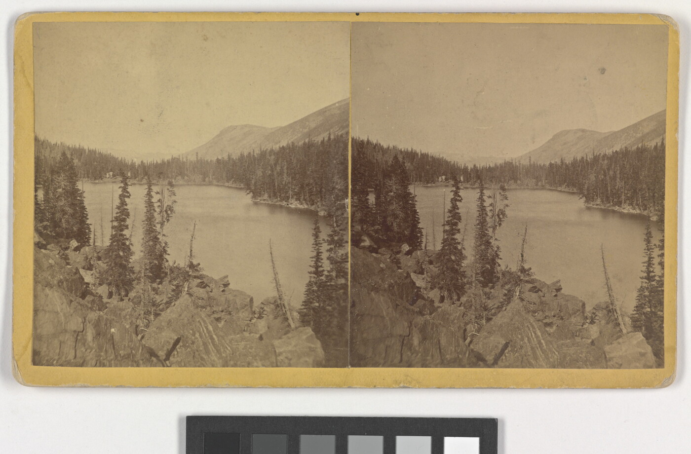 Two almost identical sepia-toned photographs side by side of a lake and rocky mountain landscape.