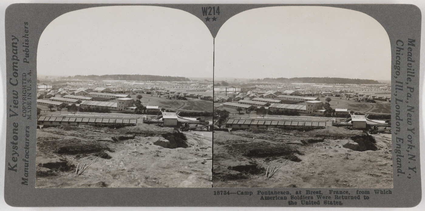Two almost identical side-by-side black-and-white photographs of a mostly flat landscape with a few trees and long, flat industrial buildings.