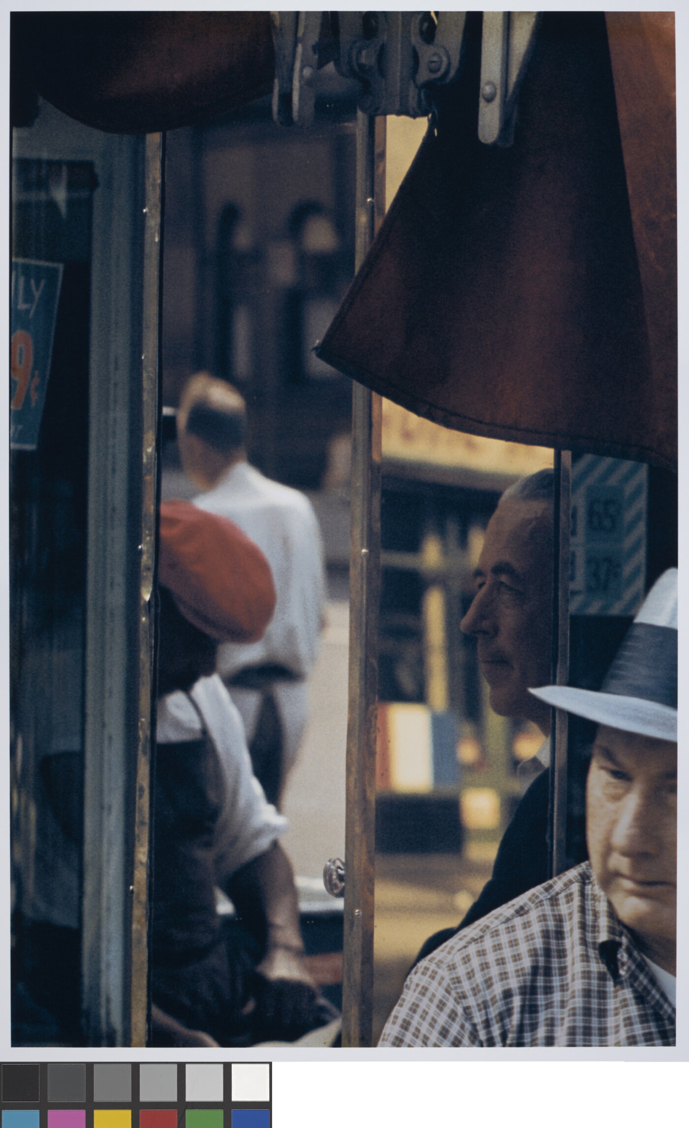 A color photograph of a four men at various angles captured in window reflections.