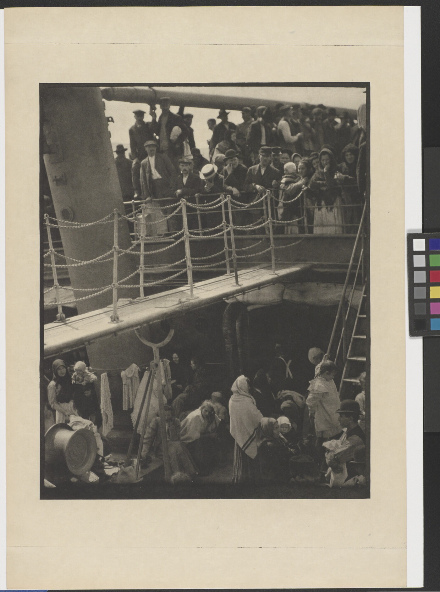 A black-and-white photograph of people outside on two decks of a crowded ship.