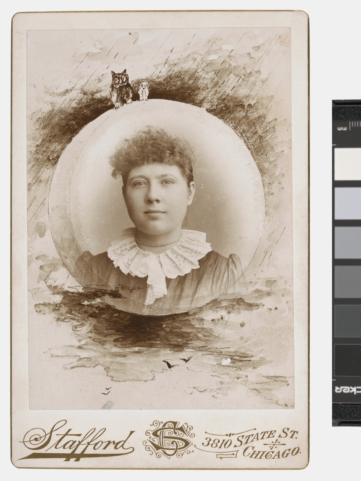 A sepia-toned, circular portrait photograph of a woman with curly hair in a lace, high-collared dress and decorative border that includes owls.