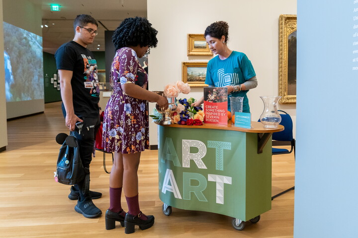 Two adults look at objects on the Carter's Art Cart.