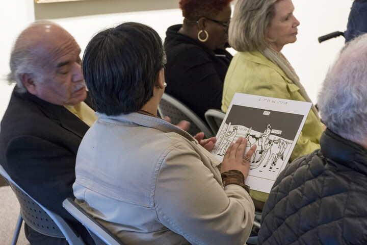 A person in a Carter gallery runs their fingers over a raised line drawing.