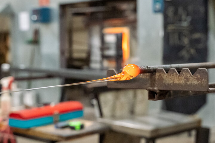 An orange-hot glob of molten glass on the end of a punty.