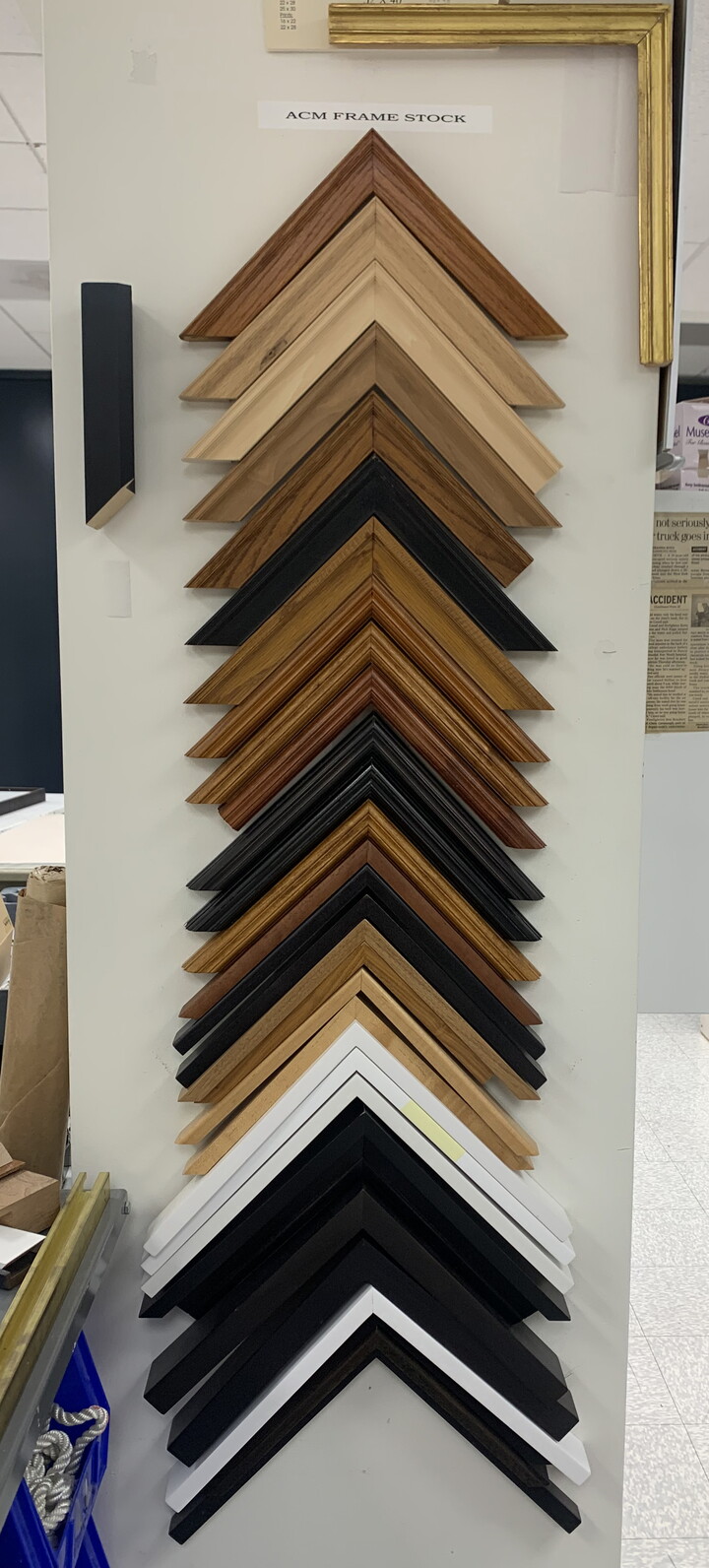 Samples of frames in various finishes hang on a pegboard.