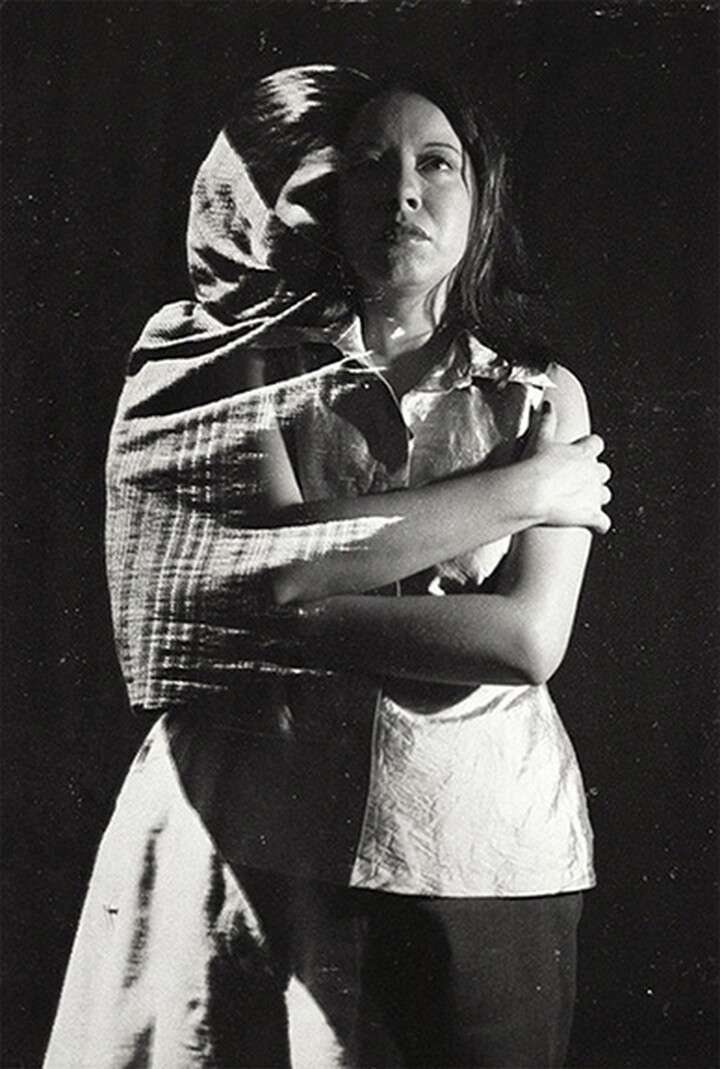 A black-and-white double-exposed photograph of two women, one in modern clothing and the other in traditional clothing, standing with their arms crossed over their chests.