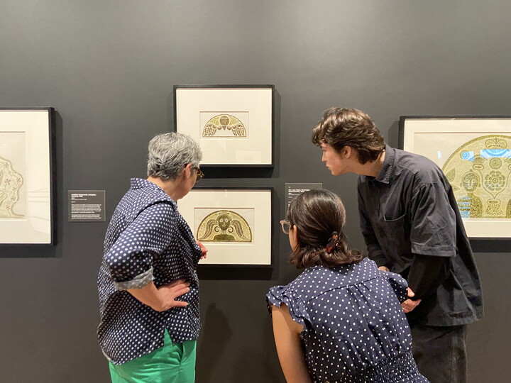 Three people look at artwork in a Carter gallery.