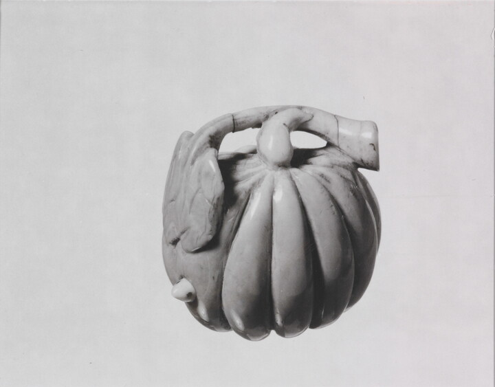 A black-and-white photograph of a ceramic pumpkin.