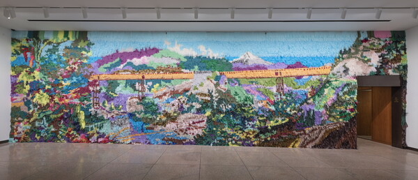 Scene of bridge and mountains made out of colored tissue paper