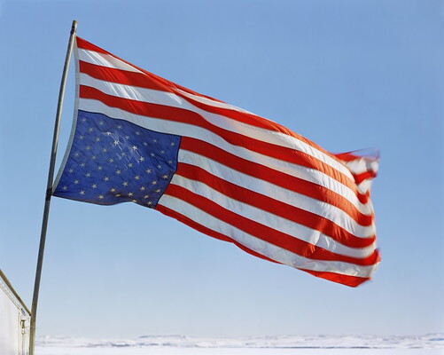 American flag flying upside down from a flagpole