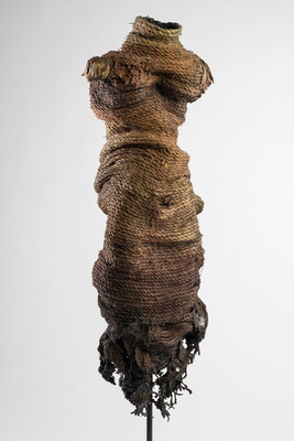 The torso of a mannequin that is wrapped in coils of old rope.