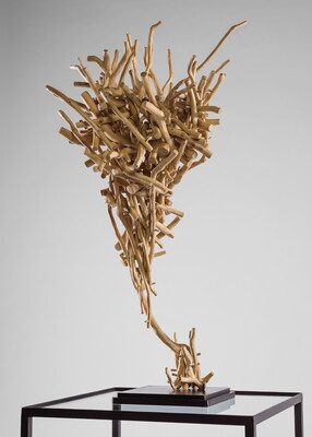 A wood sculpture composed of sticks that resembles a tornado shape.