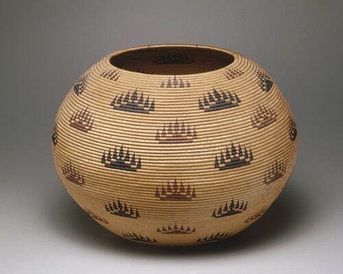 A rounded woven basket with a repeating motif in black and red of what looks like a hill with a line of trees.