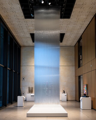 An installation view of a sculpture made of thousands of clear, glass threads hanging from the ceiling of a Carter gallery.
